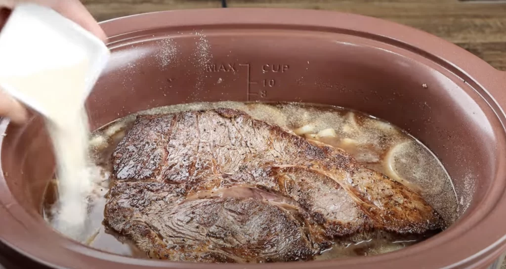 add the pot roast to the pot and season